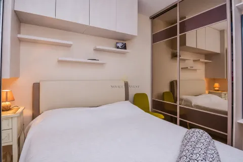 Bedroom with a double bed, built-in wardrobe and wall shelves. - image 10