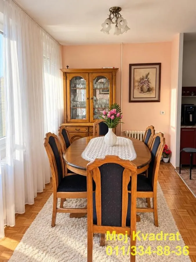 Dining area with a wooden table, chairs, and a display cabinet.