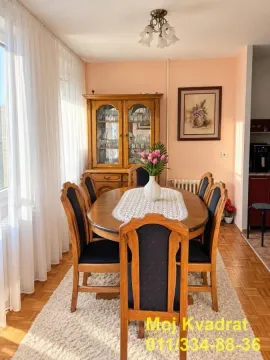 Dining area with a wooden table, chairs, and a display cabinet. - image 5