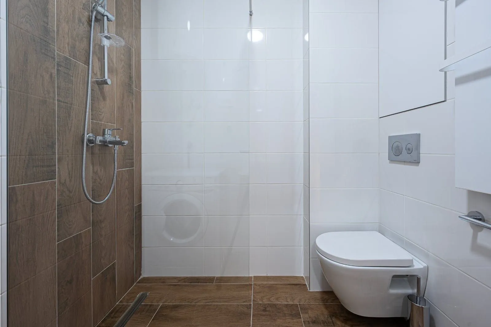 Moderne kupatilo sa tuš kabinom i ugradnom wc šoljom.