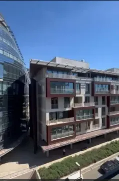 Pogled na modernu stambenu zgradu sa terasama pod plavim nebom. - image 2