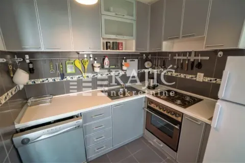 Small kitchen with grey cabinets and built-in appliances. - image 9