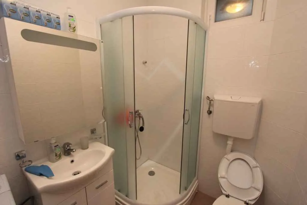 Kupatilo opremljeno tuš kabinom, umivaonikom i toaletom.