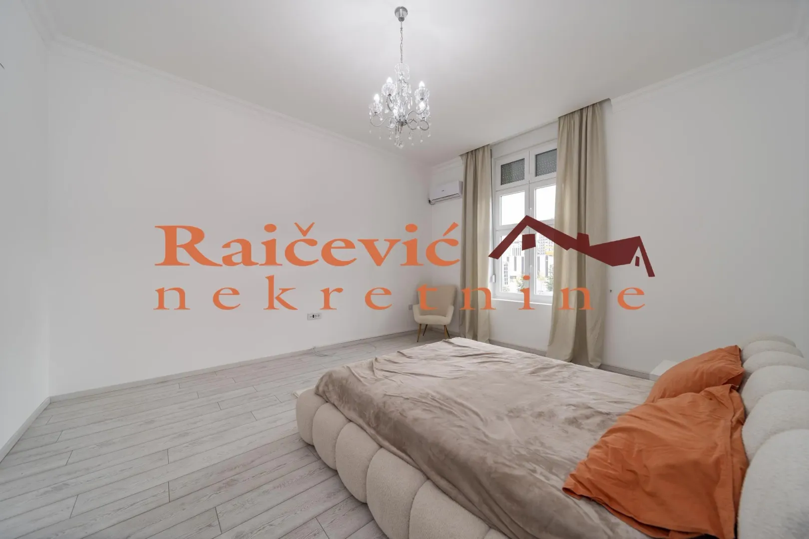 Spacious bedroom with a large double bed and a window overlooking outside.