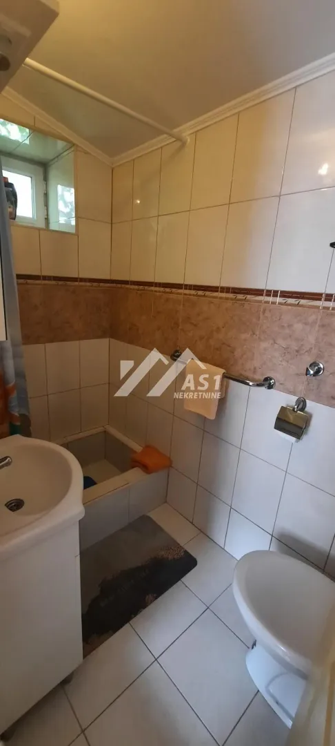 Manje kupatilo opremljeno tuš kabinom, umivaonikom i toaletom.