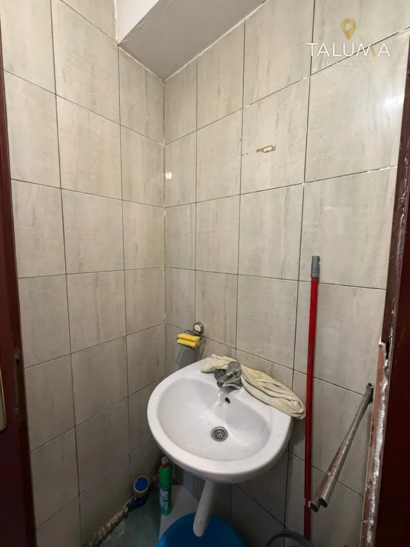 Small bathroom with a white washbasin and ceramic wall tiles.