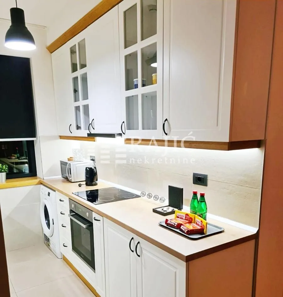 Modern white kitchen with built-in appliances and cabinetry.