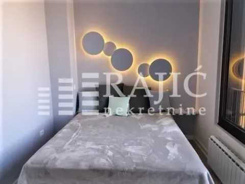 Furnished bedroom with a double bed and decorative wall panels with lighting. - image 9