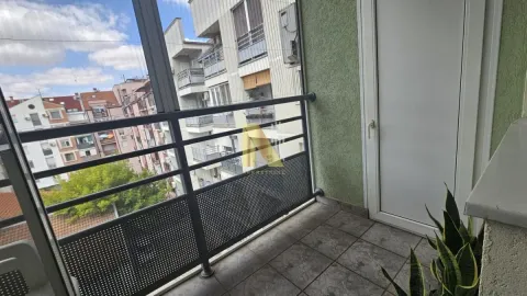Manji popločani balkon sa metalnom ogradom i pogledom na okolne zgrade. - image 4