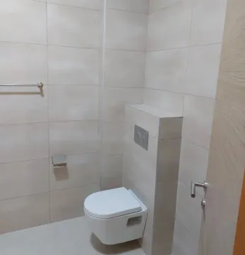 Manje kupatilo sa ugradnom wc šoljom i zidnim pločicama u svijetlim tonovima. - image 11