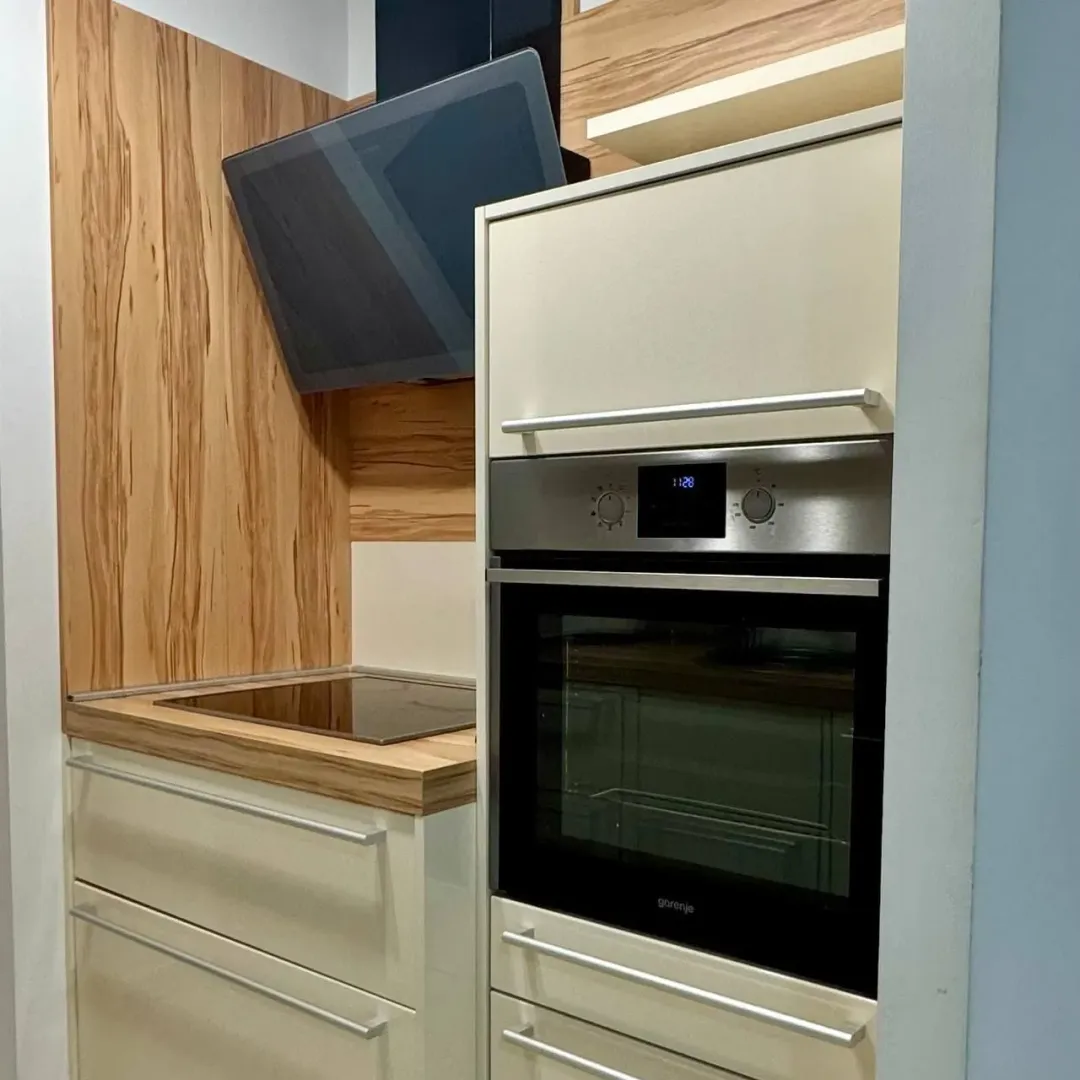 Modern kitchen with built-in oven, hob, and extractor hood.