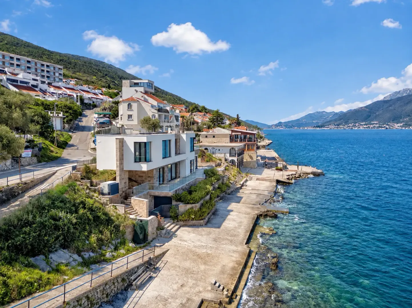 Pogled iz vazduha na obalu i primorske kuće u blizini mora.