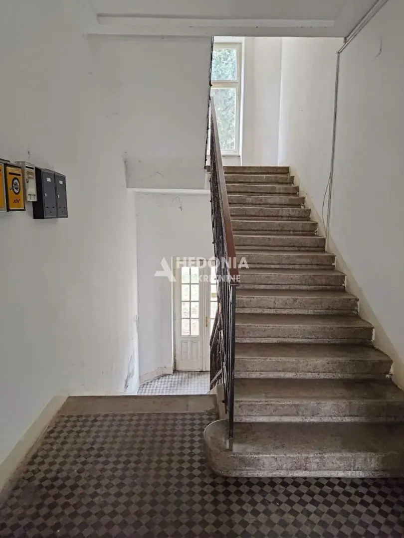 Unutrašnje stepenište i hodnik zgrade sa poštanskim sandučićima.