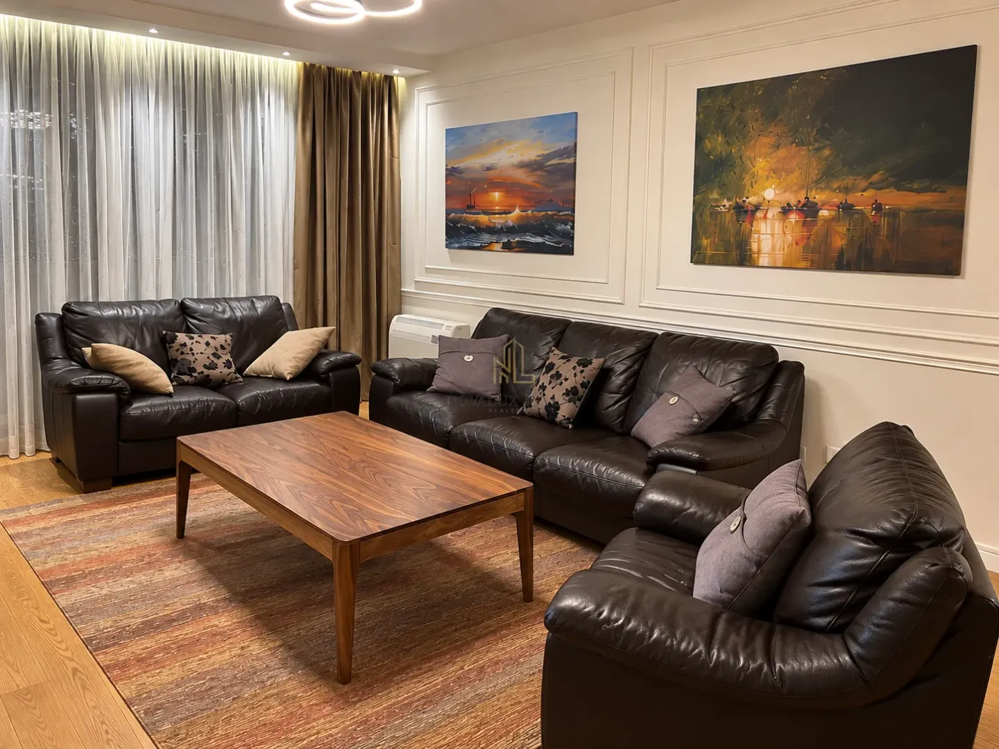Spacious living room with dark leather sofa set and a coffee table.