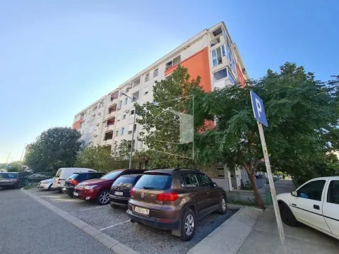 Exterior view of an apartment building with parking in front. - image 16