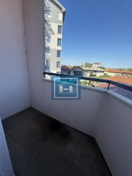Manji natkriveni balkon sa metalnom ogradom i pogledom na naselje. - image 4