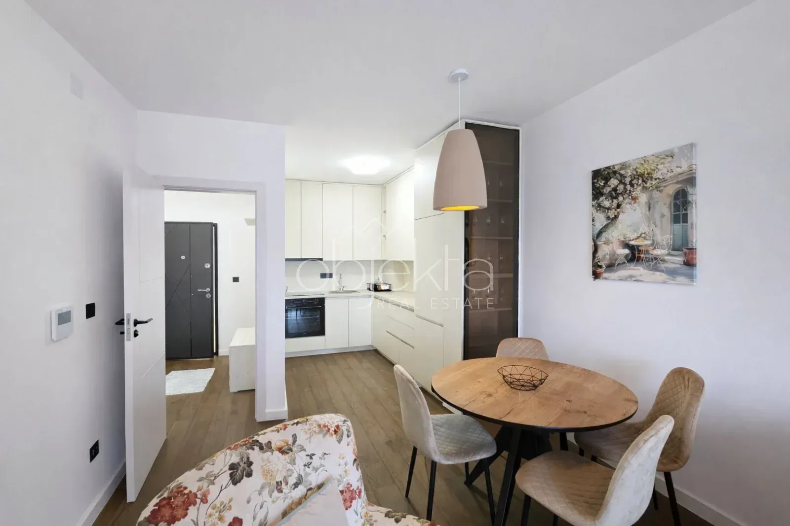 Modern kitchen with a dining area and a view toward the apartment entrance.