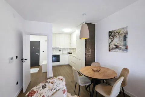 Modern kitchen with a dining area and a view toward the apartment entrance. - image 6