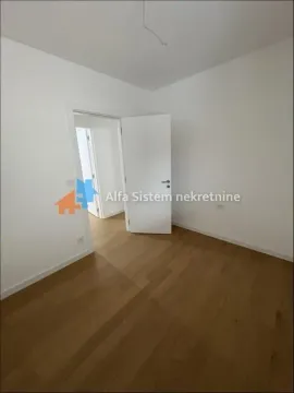 Prazna soba sa parketom i belim zidovima. - image 2