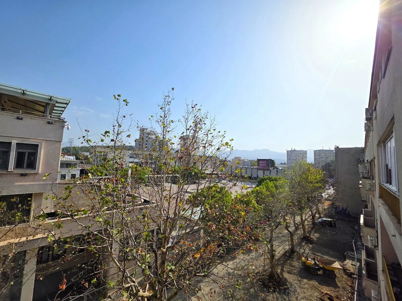 View of surrounding buildings and trees from a terrace or window.