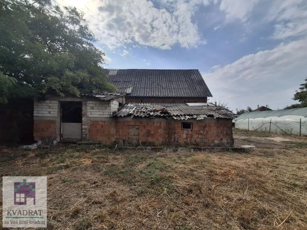 Pogled na stariju kuću sa oštećenim krovom i dvorištem.