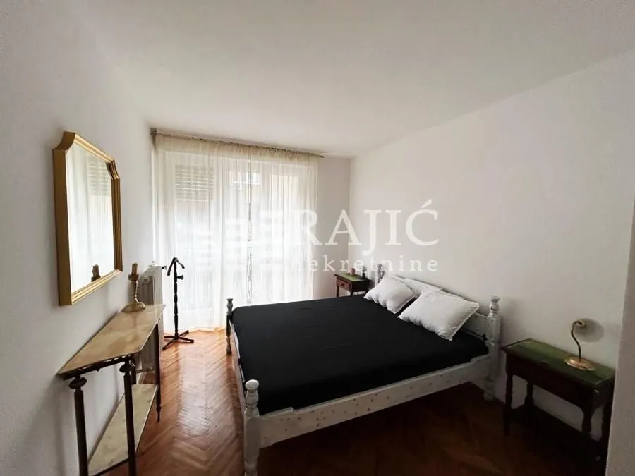 Bedroom with a double bed, mirror, and table.