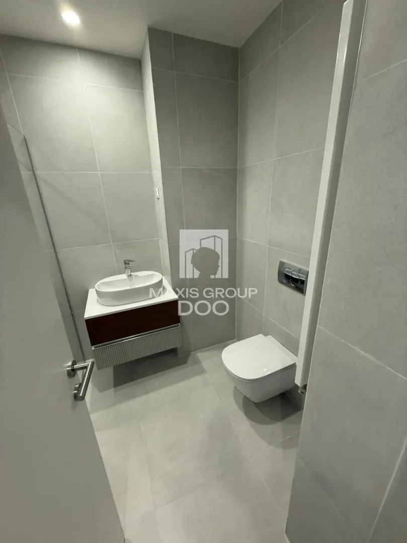 Savremeno opremljeno kupatilo sa umivaonikom i ugradnom wc šoljom.