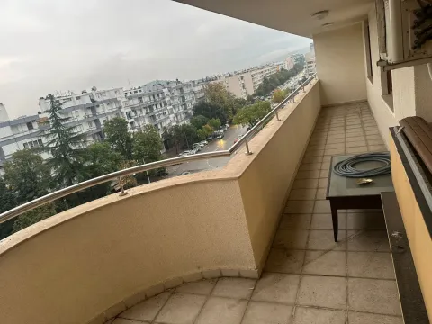 Spacious balcony with a view of the city and surrounding buildings. - image 4