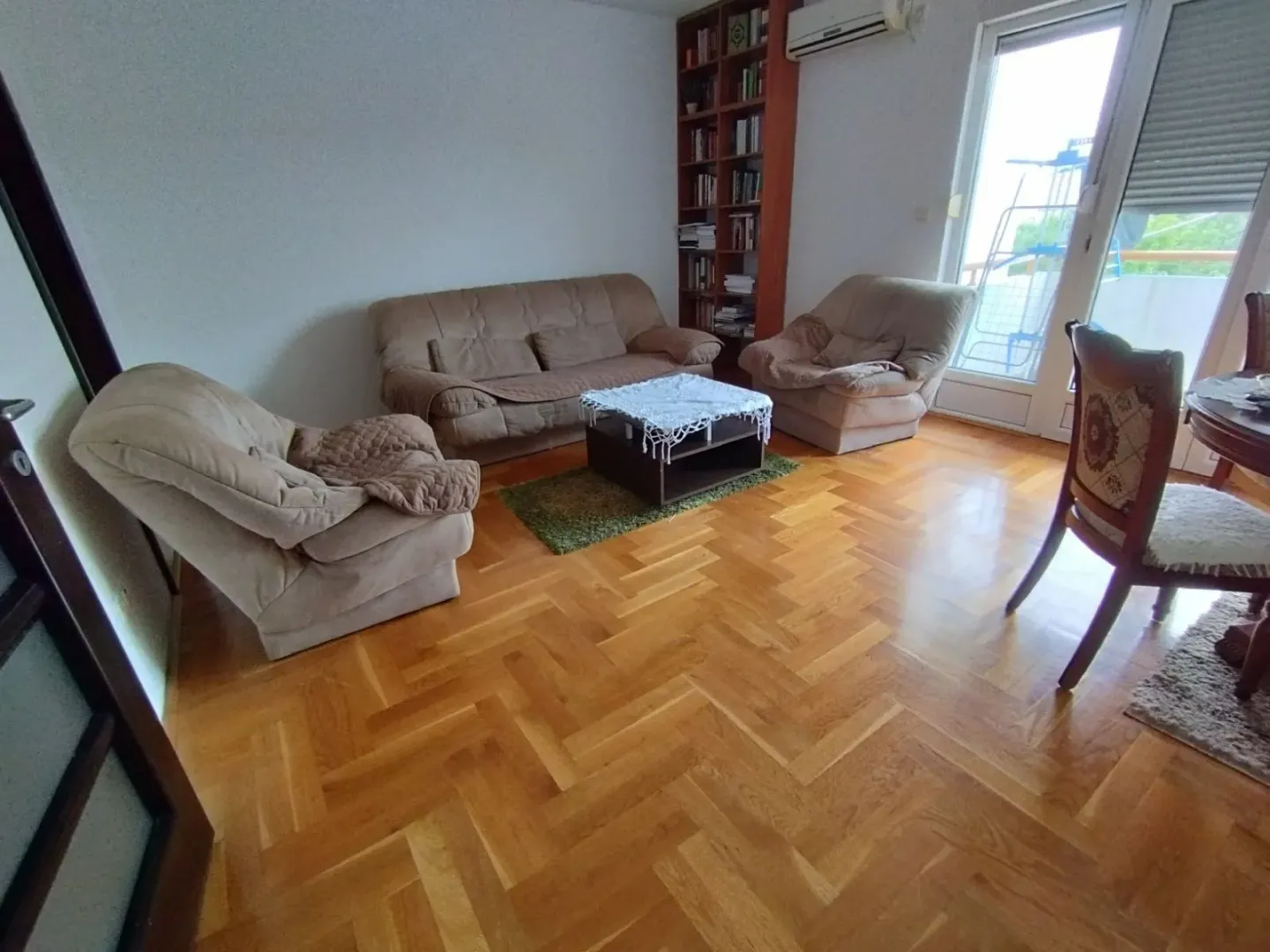 Svijetla dnevna soba sa garniturom za sjedenje.