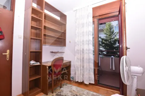 Manja soba sa drvenim radnim stolom, policama i izlazom na terasu. - image 6