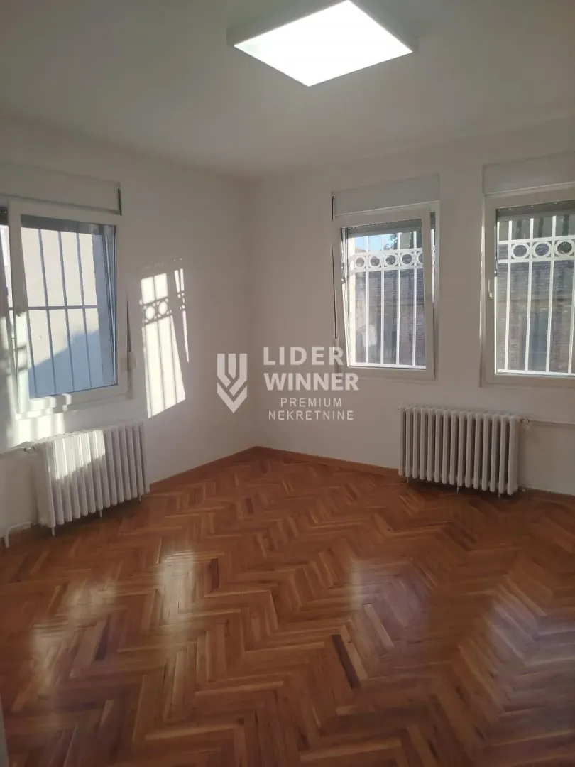 Empty room with parquet flooring and white walls.