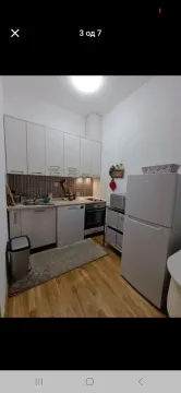 Small equipped kitchen with white cabinets and appliances. - image 4