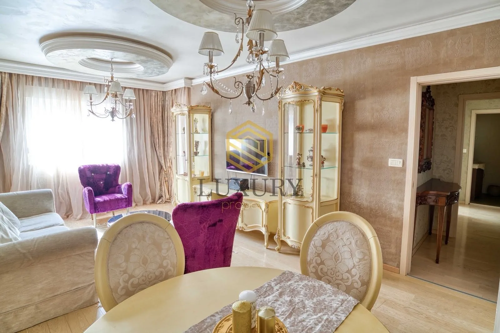 Living room with a sofa set, dining table, and classical furniture.