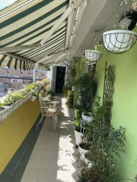 Dugačak balkon sa garniturom za sjedenje i mnoštvom saksijskog cvijeća. - image 4