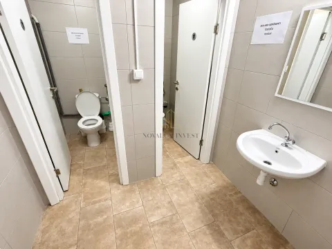 View of a modernly equipped bathroom with a washbasin and toilet cabins. - image 9