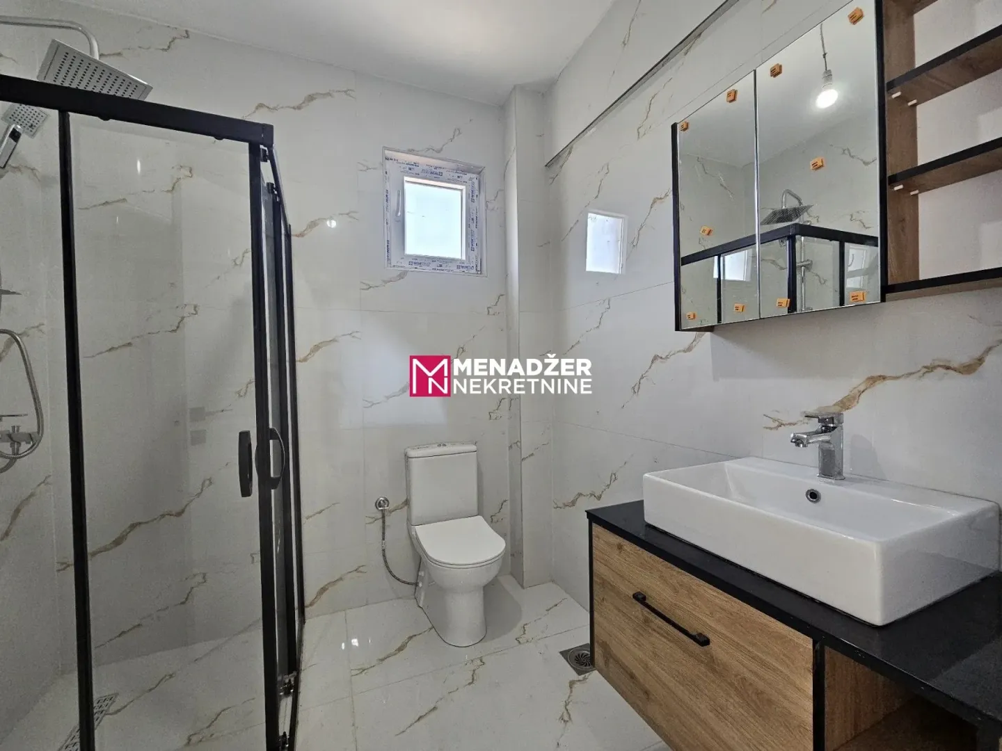 Moderne kupatilo sa tuš kabinom, umivaonikom i wc šoljom.