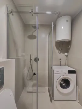 Moderno opremljeno kupatilo sa tuš kabinom i veš mašinom. - image 10