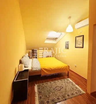 Attic bedroom with a double bed, yellow walls, and a roof window. - image 9