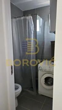 Smaller bathroom with a shower cabin and a washing machine. - image 11