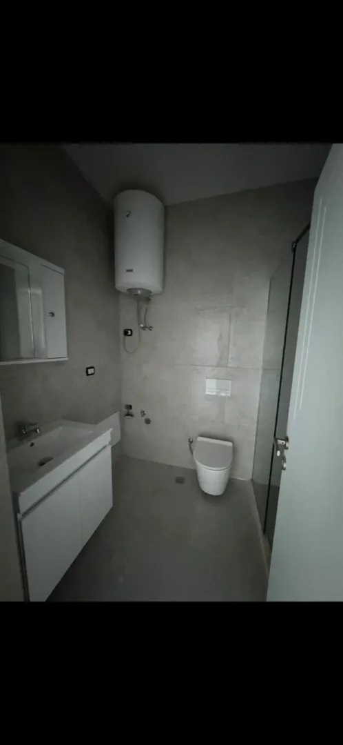 Moderno opremljeno kupatilo sa tuš kabinom.