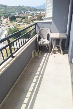 Small balcony with a table and chair and a view of the surroundings. - image 2