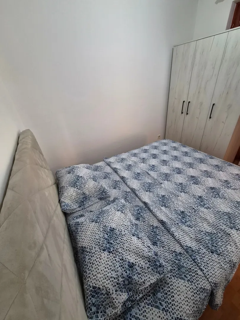 Furnished bedroom with a double bed and a wardrobe.