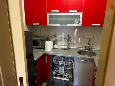 Manja kuhinja sa crvenim elementima, sudoperom i ugrađenom mašinom za pranje sudova. - image 3