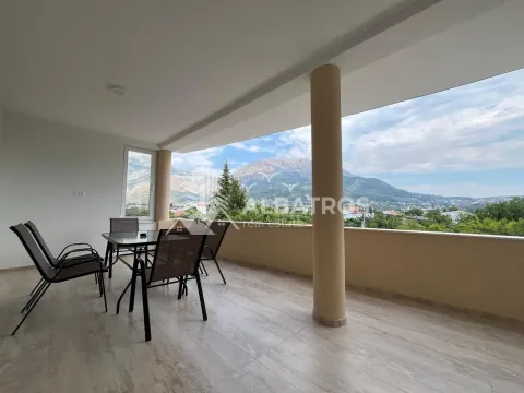 Spacious covered terrace with a dining table and mountain views. - image 11