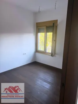Prazna soba sa tamnim parketom i prozorom. - image 4