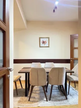 Dining room with a wooden table and beige chairs. - image 5