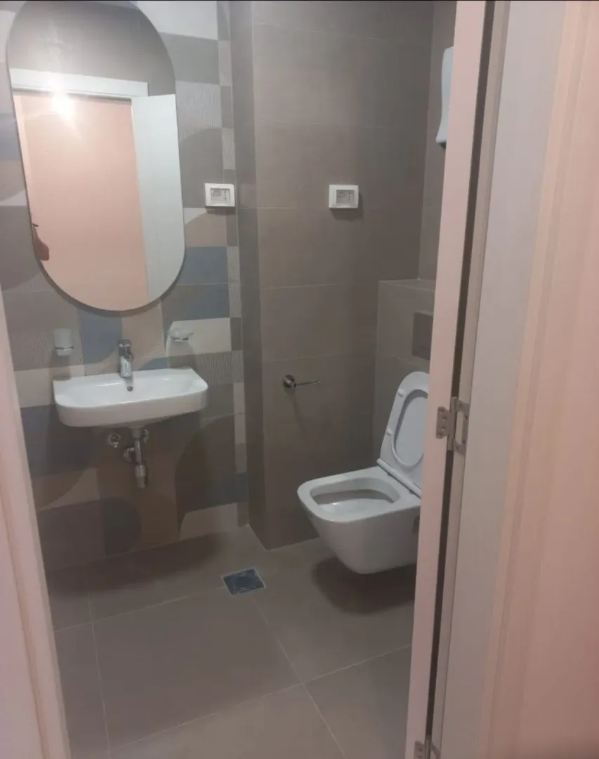 View of a modern bathroom with a washbasin and toilet.