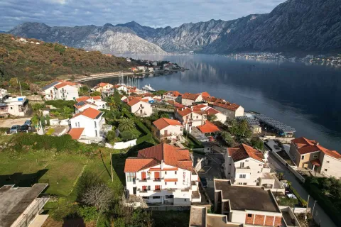 Pogled iz vazduha na priobalno naselje i zaliv sa planinama u pozadini. - image 11