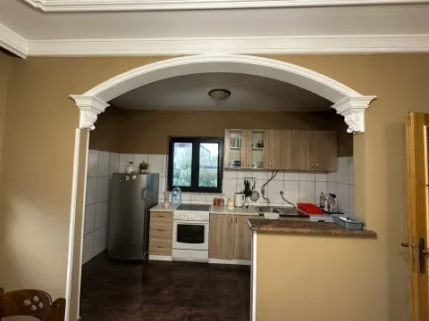 A kitchen with wooden cabinets, appliances, and a decorative archway. - image 3