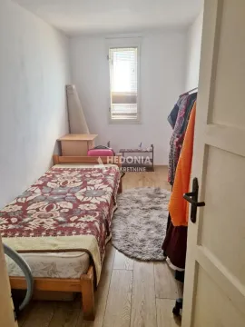 Manja spavaća soba sa krevetom i prozorom. - image 4